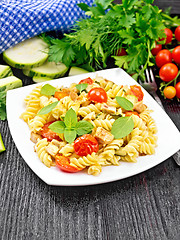 Image showing Fusilli with chicken and tomatoes in plate on black board