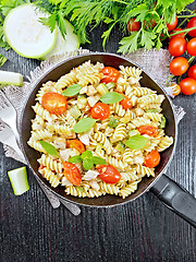 Image showing Fusilli with chicken and tomatoes in pan on black board top