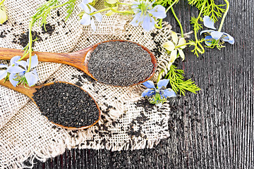 Image showing Flour and seeds of kalingi in spoons on old board top