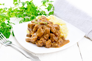 Image showing Goulash of beef with mashed potatoes in plate on wooden board