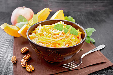 Image showing Salad of pumpkin and apple in bowl on dark board