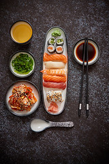 Image showing Asian food assortment. Various sushi rolls placed on ceramic plates