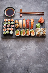 Image showing Composition of different kinds of sushi rolls placed on black stone board