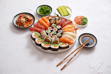 Image showing Various sushi rolls placed on round ceramic plate