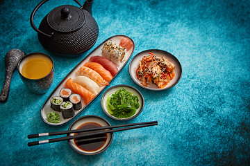 Image showing Asian food assortment. Various sushi rolls placed on ceramic plates