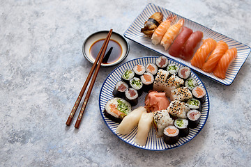 Image showing Asian food assortment. Various sushi rolls placed on ceramic plates