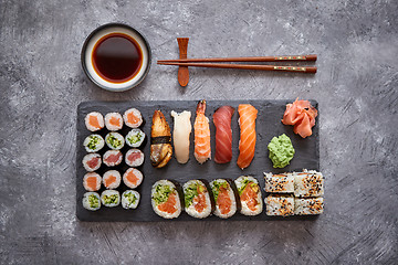 Image showing Composition of different kinds of sushi rolls placed on black stone board