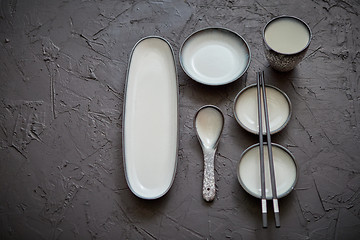 Image showing Set of empty ceramic dishes for sushi and rolls on a black stone table