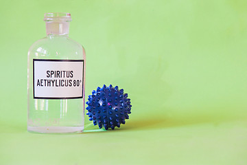 Image showing Ethanol in a bottle on the table with of microscope virus close up, Coronavirus concept Tablet in the fingers of hand