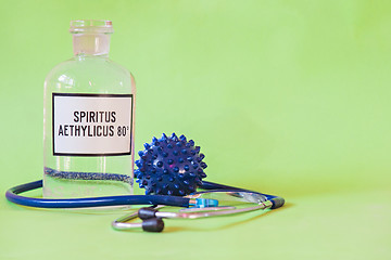 Image showing Ethanol in a bottle on the table with of microscope virus close up and stethoscope, Coronavirus concept Tablet in the fingers of hand