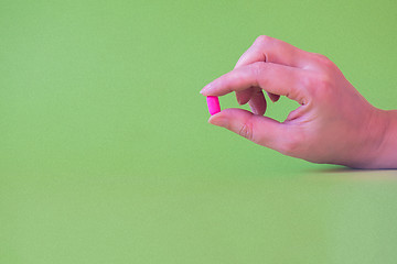 Image showing Tablet in the fingers of hand Tablet in the fingers of hand