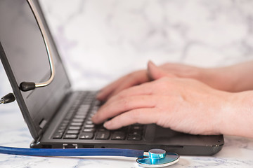 Image showing Stethoscope and notebook Tablet in the fingers of hand