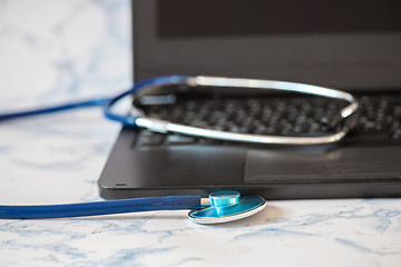 Image showing Stethoscope and notebook Tablet in the fingers of hand