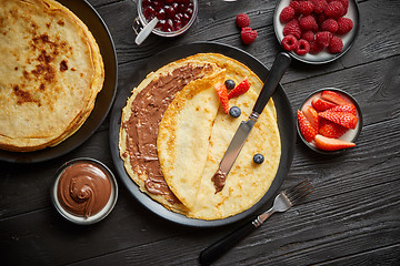 Image showing Delicious chocolate homemade pancakes on black ceramic plate