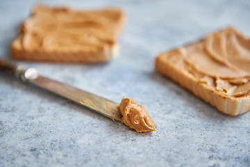 Image showing Two tasty peanut butter toasts placed on stone table