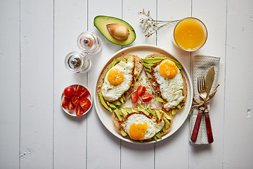 Image showing Delicious healthy breakfast with sliced avocado sandwiches with fried egg