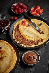 Image showing Delicious chocolate homemade pancakes on black ceramic plate