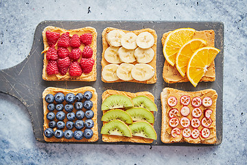 Image showing Wholegrain bread slices with peanut butter and various fruits