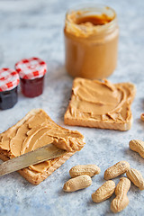 Image showing Two tasty peanut butter toasts placed on stone table