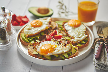 Image showing Delicious healthy breakfast with sliced avocado sandwiches with fried egg