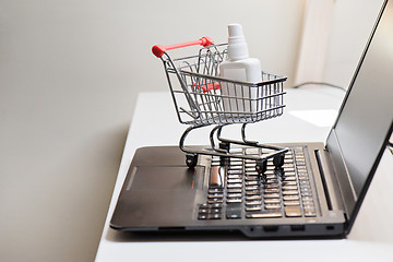 Image showing Conceptual photo with miniature shopping-cart and antiseptic. Safety internet shopping