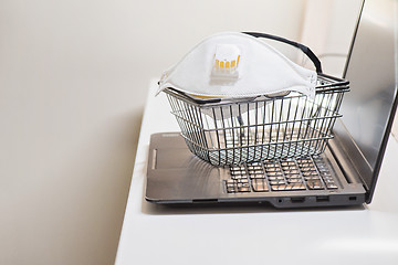 Image showing Conceptual photo with miniature shopping-basket and protecting mask and glasses. Safety internet shopping