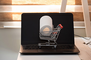 Image showing Conceptual photo with miniature shopping-cart and wc paper. Safety internet shopping.