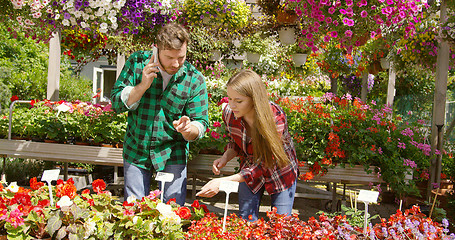 Image showing Professional gardener communicating with smartphone