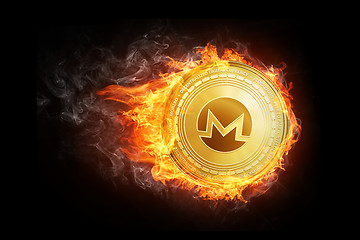 Image showing Golden Monero coin flying in fire flame.