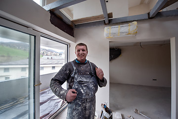 Image showing portrait of construction worker with dirty uniform in apartment