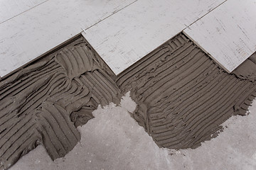 Image showing Ceramic wood effect tiles and tools for tiler on the floor