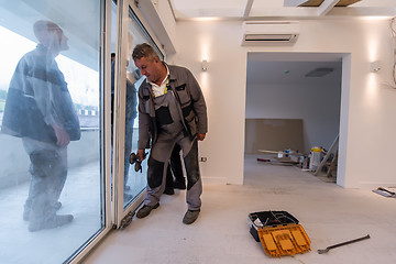 Image showing carpenters installing a balcony door