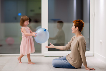 Image showing mother and cute little daughter playing with balloons