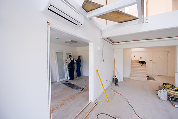 Image showing carpenters installing glass door with a wooden frame