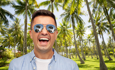 Image showing laughing man in sunglasses over tropical beach