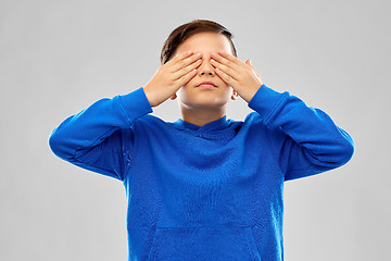 Image showing boy in blue hoodie closing his eyes by hands