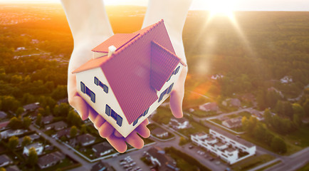 Image showing close up of hands holding house or home model