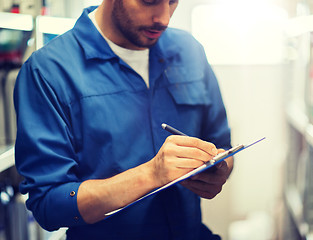 Image showing auto mechanic with clipboard at car workshop