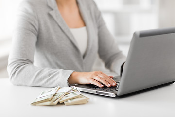 Image showing close up of businesswoman with laptop and money