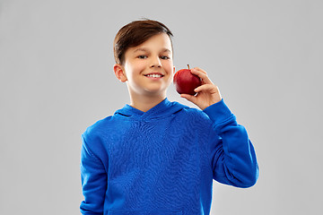 Image showing smiling boy in blue hoodie with red apple