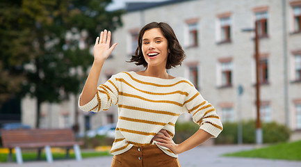 Image showing smiling woman or student girl waving hand