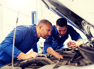 Image showing mechanic men with wrench repairing car at workshop