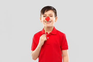 Image showing smiling boy with red clown nose party prop