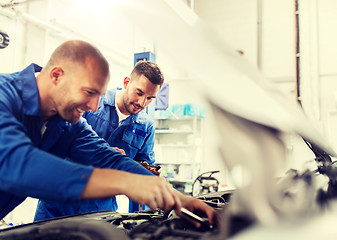 Image showing mechanic men with wrench repairing car at workshop