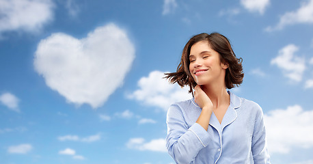 Image showing happy young woman in pajama over sky background