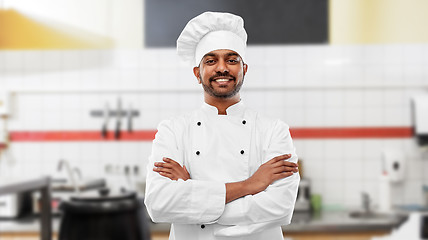 Image showing happy indian chef in toque at restaurant kitchen