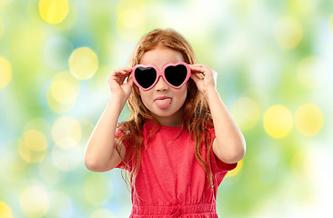 Image showing naughty red haired girl in heart shaped sunglasses