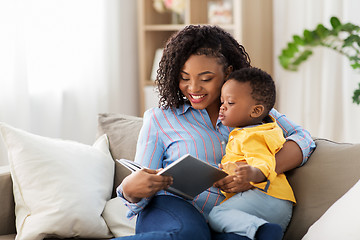 Image showing african american mother with book and baby at home