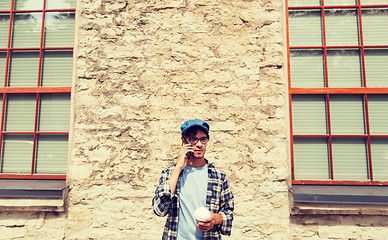 Image showing man with smartphone drinking coffee on city street