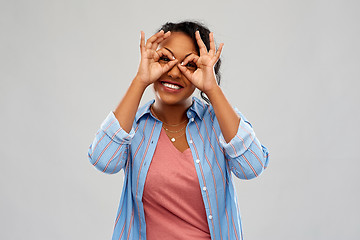 Image showing african woman looking through finger glasses